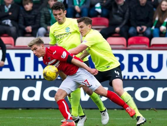 Hibs defender Paul Hanlon and Dunfermline's on-loan Hearts striker Gavin Reilly tussle for the ball watched by John McGinn