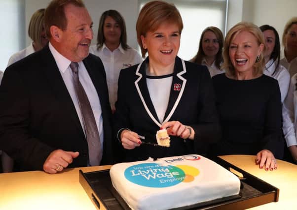Scotland's First Minister Nicola Sturgeon cuts a cake with George Bell(L) and Annette Bell  co-founders of the Bell Group during a visit to the Bell Group, a UK wide painting and decorating contractor where she announced the country's new Living Wage
Picture:  Andrew Milligan/PA