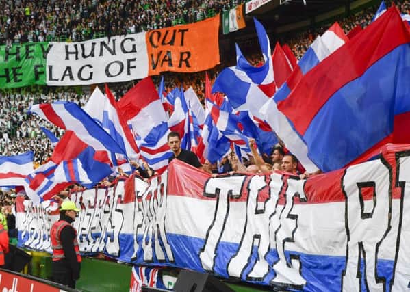 Celtic and Rangers fans hold up banners. Picture: SNS