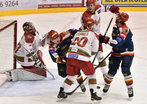 Garret Milan of the Capitals tries to strike a shot on goal but is crowded out bt Devils players. Picture: Jan Orkisz/SMP