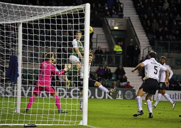 Paul Hanlon rises above Falkirk defender Luke Leahy to score Hibs' equaliser. Pic: SNS