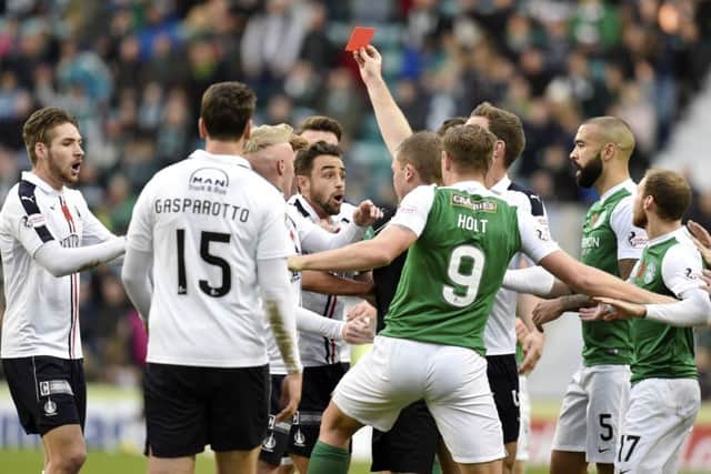 Referee John Beaton flashes the red card at stunned Falkirk midfielder Tom Taiwo. Pic: SNS