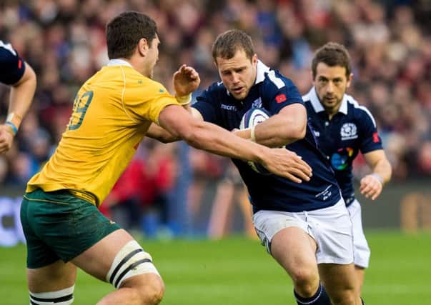 Allan Dell is watched by Scotland captain Greig Laidlaw as he tries to take on Australias Rob Simmons. Pic: SNS