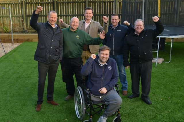 Johnnie Meechan with some of the workers who turned his garden from an uneven dangerous affair to the finished product. Picture: Jon Savage
