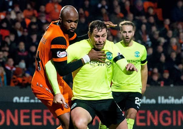 Hibs striker Grant Holt can't get the better of William Edjenguele in the defeat by Dundee United. Pic: SNS
