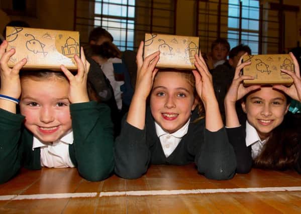 P6 pupils Aimee Foley, Anna Perry and Olivia Batcharj try out the cardboard headsets from the Google Expeditions initiative. Picture: Scott Louden