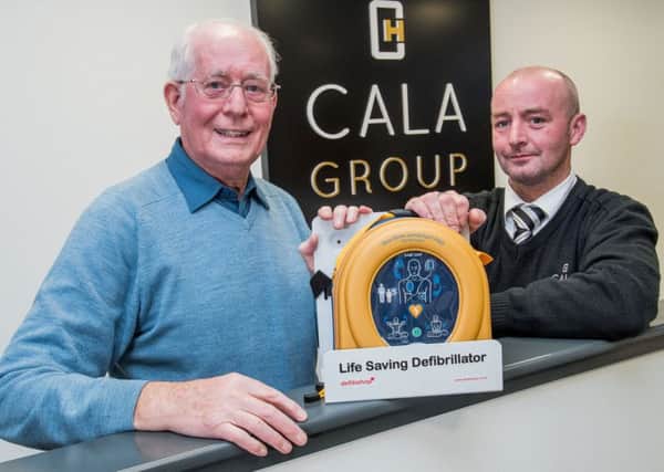Site Manger Francis Cassidy presents the defib to Allan Murray Vice Chair of Currie Community council
. Picture: Ian Georgeson