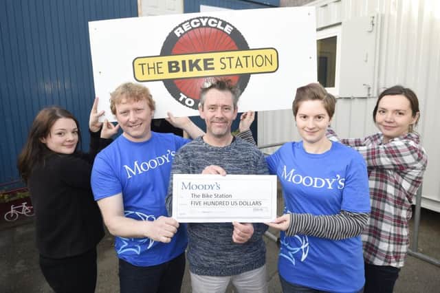 Pic Greg Macvean - 01/12/2016 - The Bike Station on Causewayside have launched a crowd funding campaign to get back in business after a fire destroyed their building - l-r Jennifer Baker, Craig Smith (Moody's), Steve Hynd (owner), Ellen Moar (Moody's), Sylwia Zelazna with a cheque for $500 from Moody's