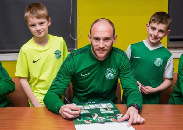 David Gray joined in at a Hibs calendar signing evening with fans Thomas Yates and Craig Gilluley, both aged nine. Picture: Ian Georgeson