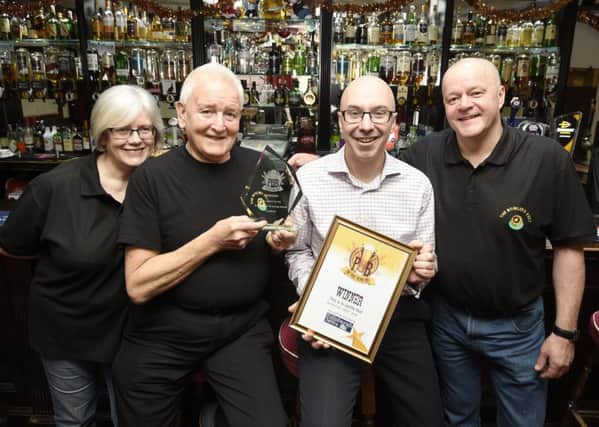 Euan McGrory presents the Evening News Pub of the Year award to the owner of Bowlers' Rest Eric Morrison pictured with his daughter Carole McKenzie and her husband Ross McKenzie. Pic credit: Greg Macvean.