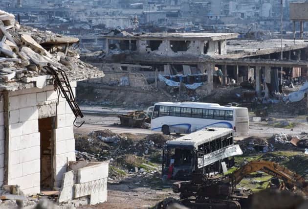 A bus drives through the government-controlled crossing of Ramoussa, on the southern outskirts of Aleppo, on December 18, 2016, during an evacuation operation of rebel fighters and civilians from rebel-held areas.