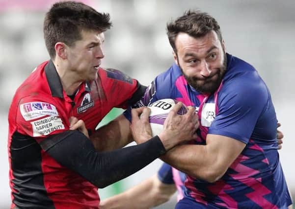 Edinburgh full-back Blair Kinghorn grapples for the ball with Stade Francais player Jeremy Sinzelle