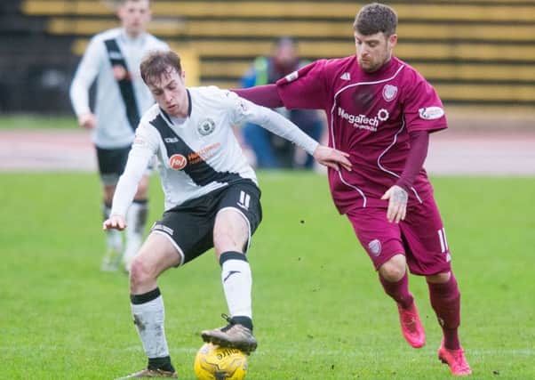 Mark McConnell takes on Arbroath's Bobby Linn. Picture: Ian Georgeson