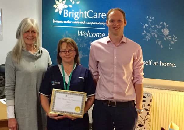 Lois McNeil receives her Care Worker of the Year award from Bright Care manager Annie Brown and director Tim Cocking