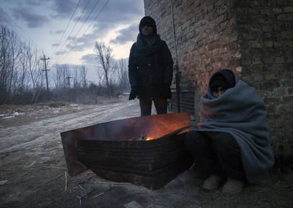 Migrants warm themselves by the fire outside of derelict brickyard  in Subotica, Serbia. Homeless refugees face a desperate battle against freezing temperatures in the Balkans. Photograph: Srdjan Stevanovic/Getty