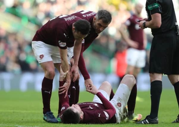 Hearts John Souttar is comforted by his team-mates after rupturing his Achilles tendon against Celtic. Pic: SNS