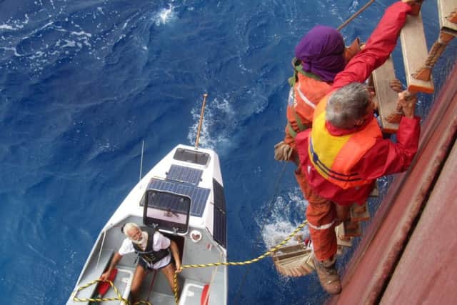 Fenella McAlister(R) is helped aboard the merchant ship Glyfade after needing to be rescued when the rowing as damaged in the Atlantic. Picture; SWNS
