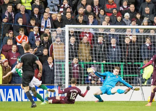 Jason Cummings, left, fires home the opening goal in front of the Hearts fans. Picture: Ian Georgeson