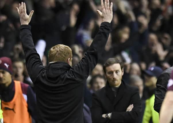 Hearts head coach Ian Cathro is dejected as Hibs counterpart Neil Lennon celebrates his side's win