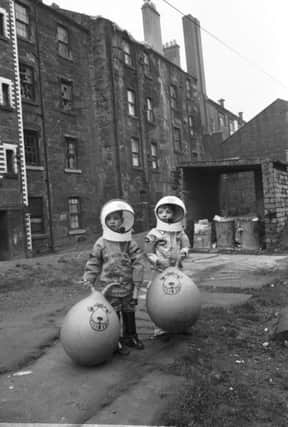 Little boys show off their Christmas presents, including astronaut suits and Space Hoppers, in Crown Street in the Gorbals area of Glasgow in December 1970. PIC: TSPL.