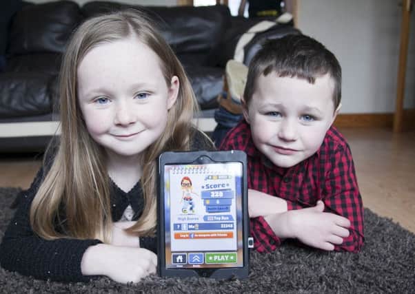 Zoey Kerr, 7, and her brother Riley Kerr, 4, with her returned ipad after it was found in a landfill site. Picture; PA