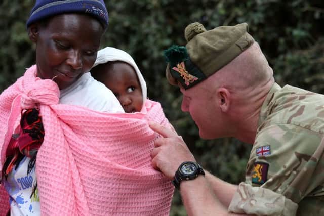 Private Beggs from Balaklava Company with locals after handing out donated clothes to villagers at a community hall in Nanyuki. Picture; PA