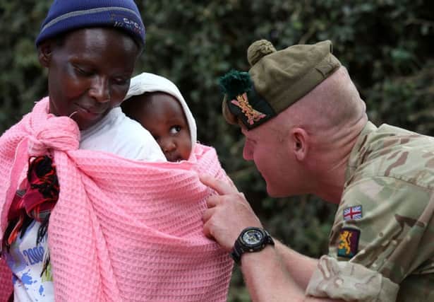 Private Beggs from Balaklava Company with locals after handing out donated clothes to villagers at a community hall  in Nanyuki. Picture; PA