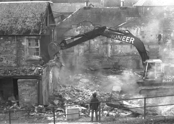 A wrecking machine rips the wall of Polton Mill in Lasswade when it is demolished in March 1981. Photo: Albert Jordan