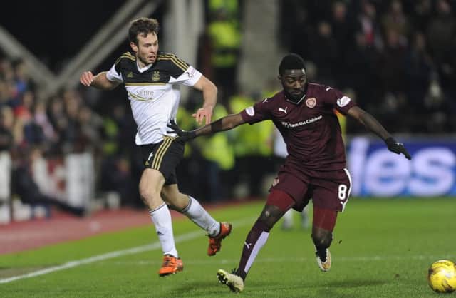 Prince Buaben, left, beats Andrew Considine to the ball at Tynecastle