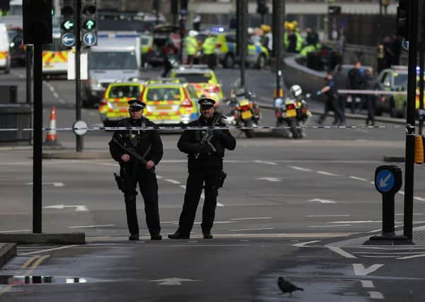 Armed police officers stand guard on the corner of Parliament Square, near the Houses of Parliament in central London during an emergency incident. 
Police shot dead  a suspected attacker outside the Houses of Parliament in London on after an officer was killed in what police said was a "terrorist" incident. Picture: Getty Images