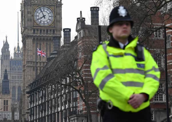 A policeman stands guard at the Houses of Parliament, where flags are flying at half-mast. Picture: AFP