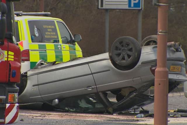 Three men have been injured after a car overturned onto its roof following a crash with another vehicle on South Gyle Broadway. Picture: BBC Scotland