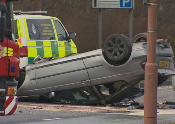 Three men have been injured after a car overturned onto its roof following a crash with another vehicle on South Gyle Broadway. Picture: BBC Scotland