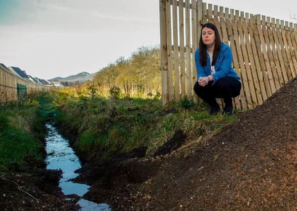 Kelly McGarvey of Bilston at the open drain outside her property.