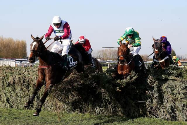 One For Arthur ridden by jockey Derek Fox jumps the last on the way to winning the Randox Health Grand National. Picture PA