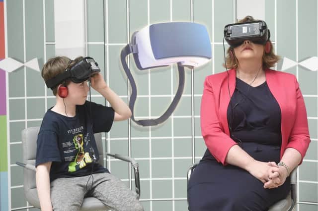 Cabinet secretary Fiona Hyslop tries out a virtual reality helmet along with Ben Burnet (10) during a visit to the 2017 Edinburgh International Science Festival. Picture: Greg Macvean/JP Resell