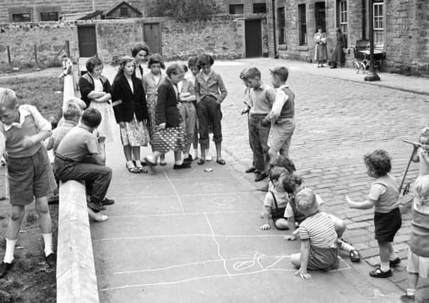 Children playing peevers (hopscotch) in the street - picture taken in Lapicide Place in Leith.