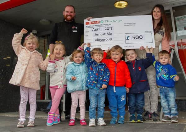 Store manager Danny O'Donnell with Lauren Burrell and the kids of Amuse Me Playgroup to celebrate the raising of Â£500 at the store for the charity.