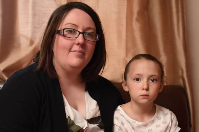Megan Donald, 7, from Kirkintilloch, Scotland, with mum Natalie, 31, whose tongue got stuck in a Disney Monster Inc cup. Picture: SWNS