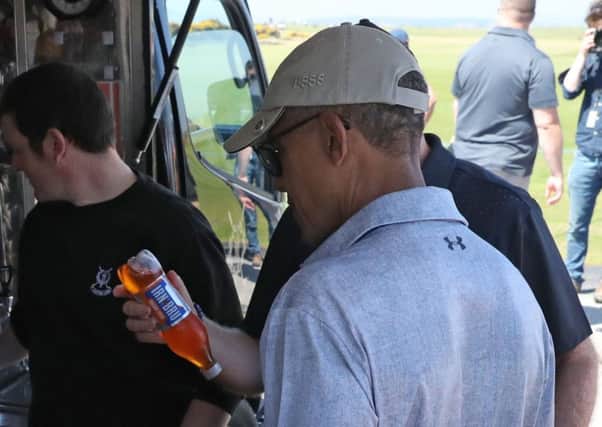 Sir Tom Hunter shows a bottle of Irn-Bru to Barack Obama as they stop at a snack bar at the Old Course in St Andrews. Picture: PA