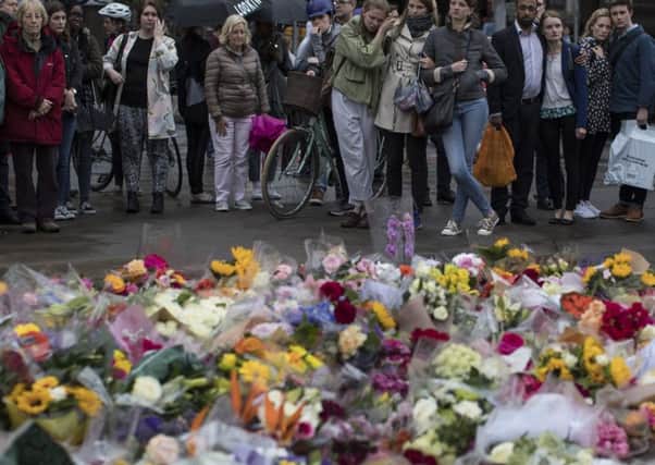 Members of the public gather near flowers on the South side of London Bridge. Picture; Getty