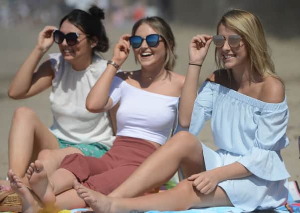 Christie Smith, 18, Dayna Clark, 18, and Melissa Condie, 18 from Aidrie, on Ayr beach as temperatures soared in May this year. Picture: SWNS