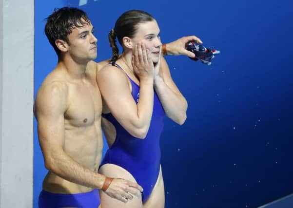 Grace Reid and Tom Daley wait to hear that they won silver after their performance in the mixed 3m synchro springboard diving final. Picture: AP Photo/Darko Bandic