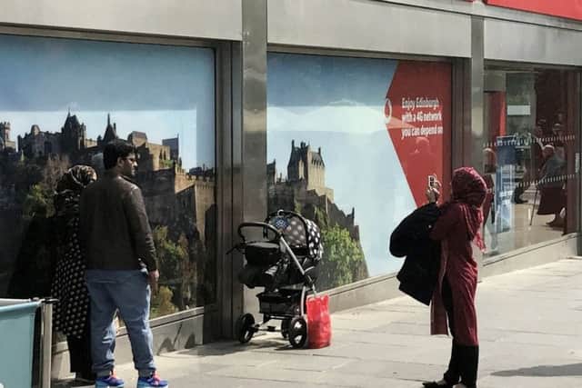 Tourists taking a picture of themselves beside a picture of Edinburgh Castle when they were standing in front of the real thing spotted by Andy Glidden. Picture; SWNS
