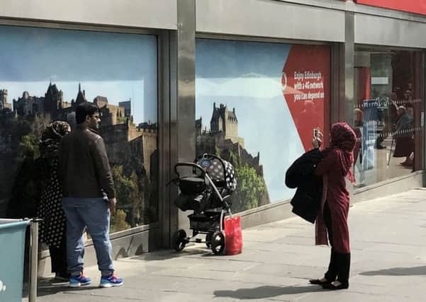Tourists taking a picture of themselves beside a picture of Edinburgh Castle when they were standing in front of the real thing spotted by Andy Glidden. Picture; SWNS