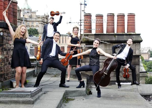 Members of the Catalonian string orchestra Orquestra de Cambra d'Emporda on the rooftops over edinburgh