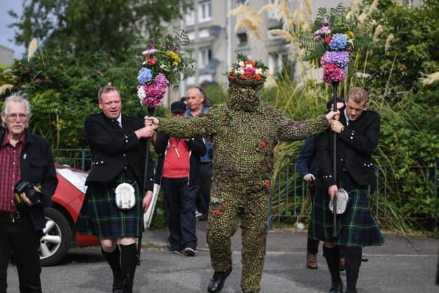 Burryman Andrew Taylor meets residents as he parades through the town encased in burrs. Picture: Getty