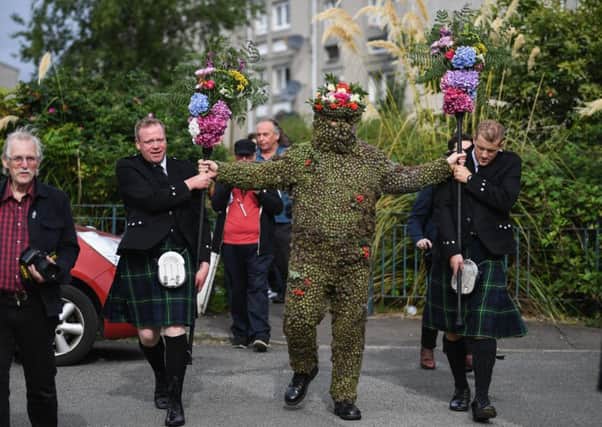 Burryman Andrew Taylor meets residents as he parades through the town encased in burrs. Picture: Getty