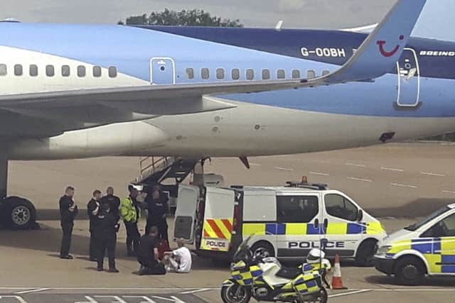 Police vehicles surround a Thomson aircraft at Bristol airport as officers arrest Derek Root and Alexander Gray. Picture: SWNS