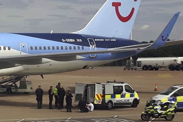 Police vehicles surround a Thomson aircraft at Bristol airport as officers arrest Derek Root and Alexander Gray. Picture: SWNS